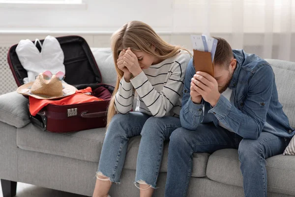 一对绝望的夫妇坐在打包好的行李箱旁 — 图库照片