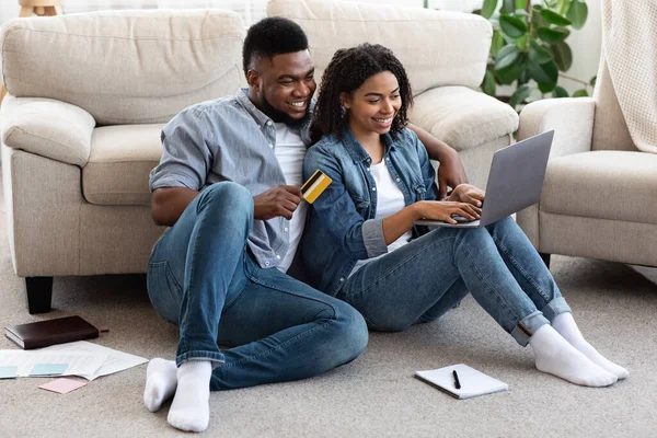 Sorridente coppia nera utilizzando carta di credito e computer portatile per lo shopping online — Foto Stock
