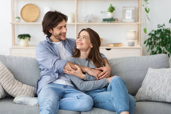 Encantador jovem casal abraçando em sua sala de estar — Fotografia de Stock