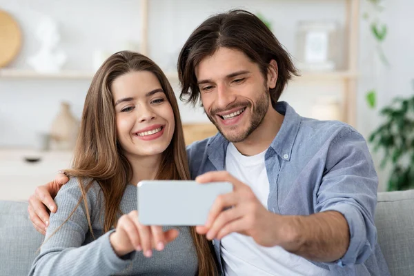 Pozitivní pár v lásce brát selfie doma — Stock fotografie