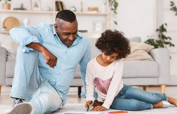 Fica em casa, sê criativo. Família afro-americana de avô e neta desenhando no chão em casa — Fotografia de Stock