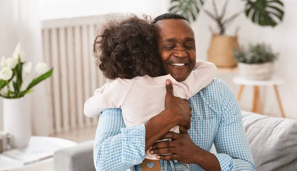 Relação de netos avós. Sênior afro-americano abraçando sua neta em casa — Fotografia de Stock