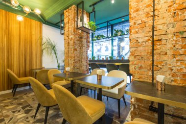 Büyük pencereli ve duvarları kırmızı tuğlalı restoranın çatı katı.