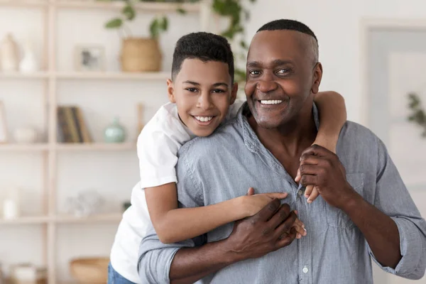 Uma ligação familiar. retrato de feliz preto preteen menino abraçando seu avô — Fotografia de Stock