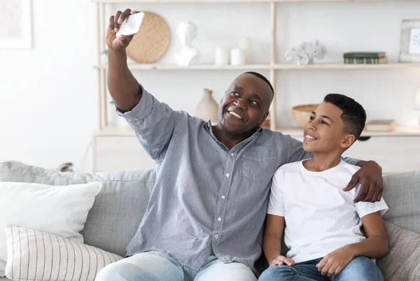 Σπίτι Selfie. Χαμογελώντας μαύρο παππού με προεφηβική εγγονός λήψη φωτογραφιών μαζί — Φωτογραφία Αρχείου