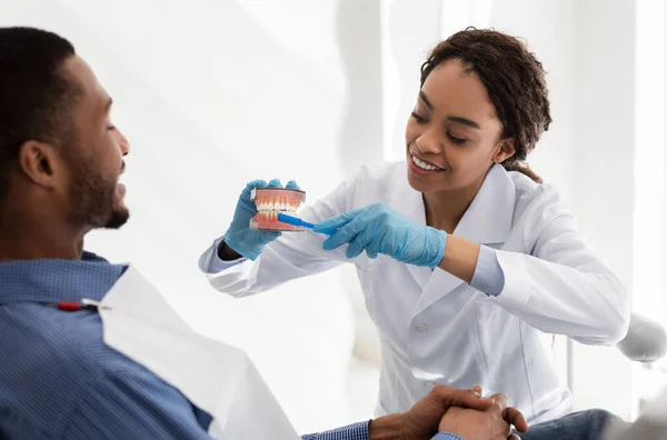Pozitif dişçi doktoru hastaya diş fırçalamayı anlatıyor. — Stok fotoğraf