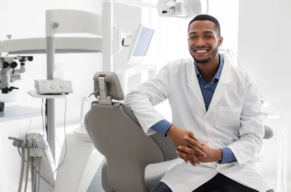 Modern klinikte çok nitelikli genç bir dişçi poz veriyor. — Stok fotoğraf