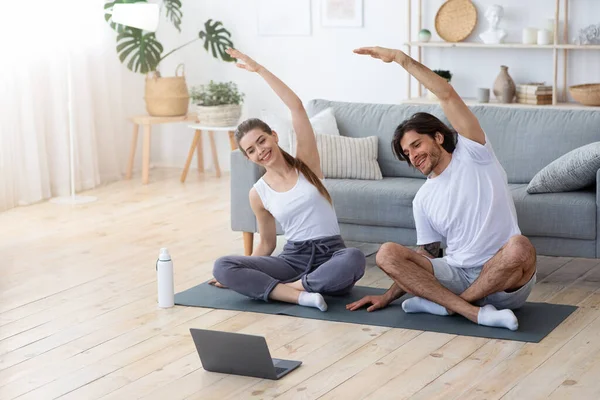 건강 한 부부가 노트북을 사용하여 집에서 운동을 한다 — 스톡 사진