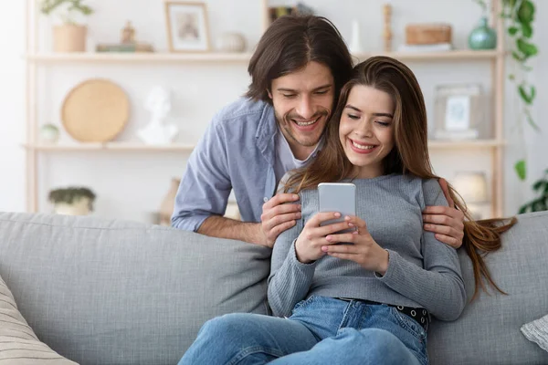 Χαρούμενο ζευγάρι βλέποντας φωτογραφίες στο σύγχρονο τηλέφωνο — Φωτογραφία Αρχείου
