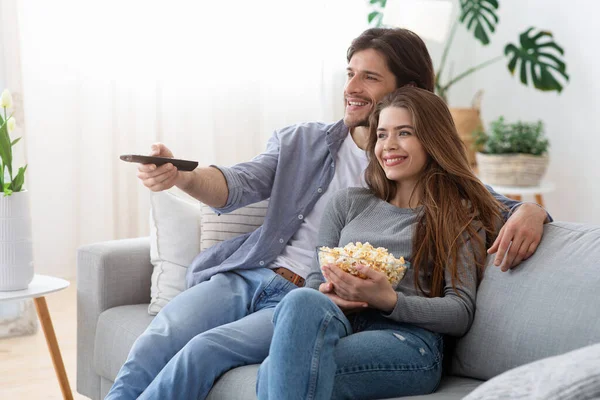 Feliz casal assistindo filme em casa, comendo pipocas — Fotografia de Stock