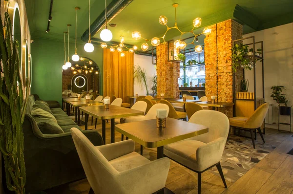 Modern tarzda bir restoran, yeşil duvarlı açık renk iç mekan.