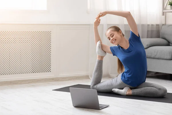 Flexible chica estirándose en casa con el entrenador a través de Internet —  Fotos de Stock