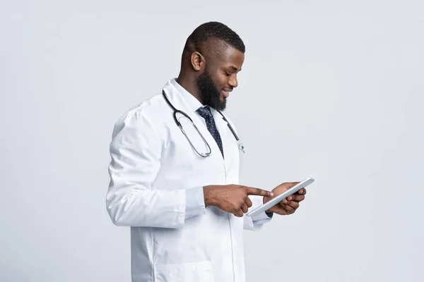 Terapeuta maschio nero amichevole con tablet digitale — Foto Stock