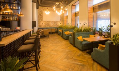 Masaları ve kanepeleri olan modern bir restoran, bar tezgahı.