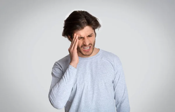 Mann leidet an Kopfschmerzen, auf leichtem Hintergrund — Stockfoto