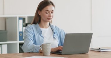 Neşeli kadın laptopta ortaklarıyla sohbet ediyor.