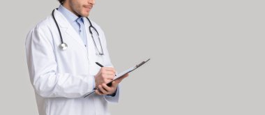 Tanımlanamayan erkek terapist hastaların tıbbi geçmişlerine notlar yazıyor.