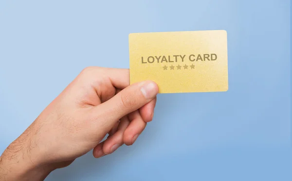 Marketing and client relations. Young guy showing loyalty card on blue background, close up of hand. Collage