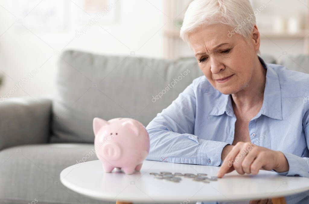 No retirement savings. Upset elderly woman counting coins from piggy bank