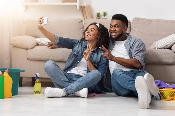 Θετικό μαύρο ζευγάρι λαμβάνοντας selfie στο smartphone μετά την τακτοποίηση διαμέρισμα μαζί — Φωτογραφία Αρχείου
