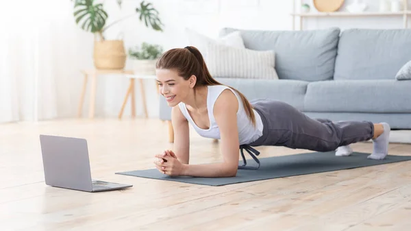 Positive Mädchen planken zu Hause, morgens Sport machen — Stockfoto