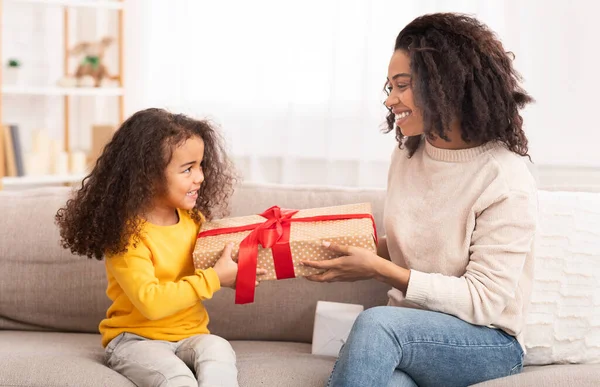 Dochter geven Geschenk naar mam zitten op bank thuis — Stockfoto