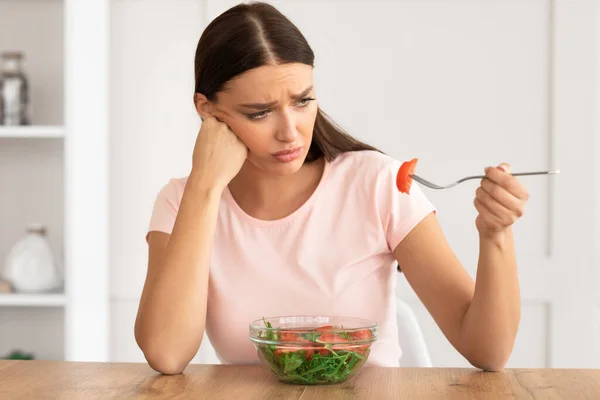 Triste fille manger de la salade de légumes perdre du poids à la maison — Photo