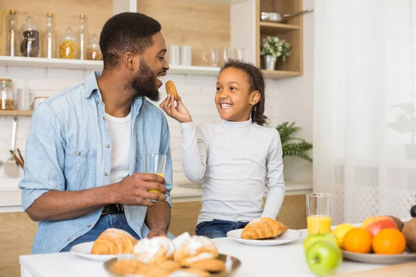 Mutlu aile kurabiye yer ve mutfakta meyve suyu içer. — Stok fotoğraf