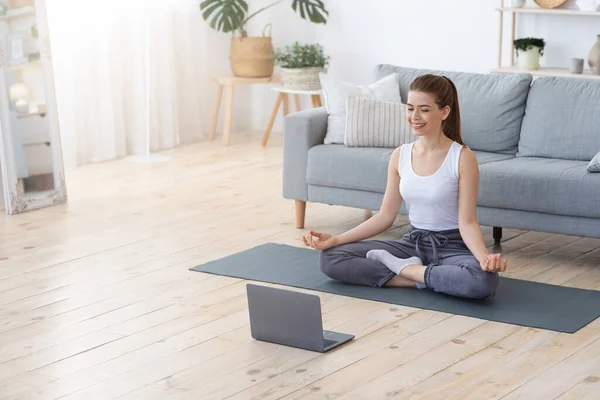 집에서 노트북을 사용하여 평화롭게 명상하는 소녀 — 스톡 사진