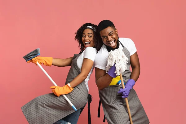Positive black couple enjoying cleaning together, having fun with mop and broom — Stock Photo, Image