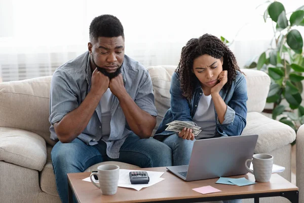 Problemas financieros. Pareja negra molesta administrando el presupuesto familiar juntos en casa — Foto de Stock