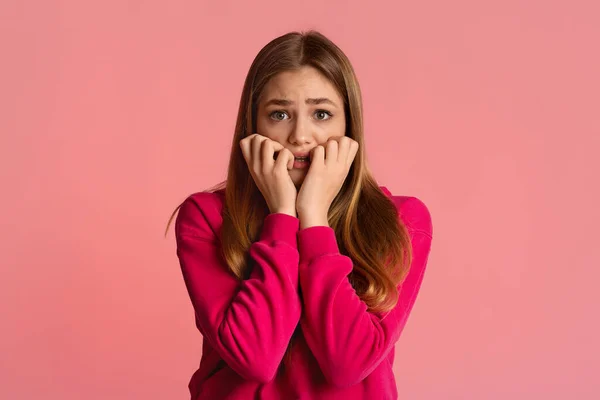 Дівчина-підліток боїться, ізольована на рожевому фоні — стокове фото