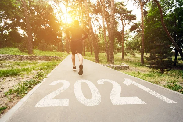 Collage von motiviertem Jogger, der auf Pfad mit Aufschrift "2021" läuft — Stockfoto