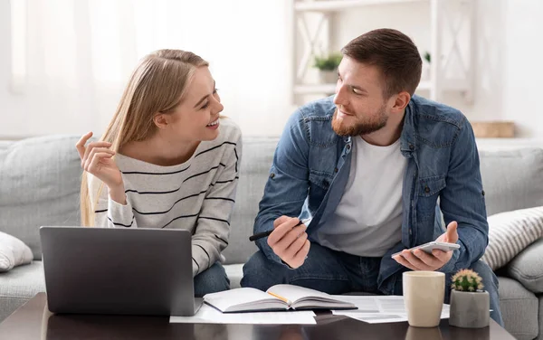 Positives junges Paar rechnet Finanzen zu Hause ab — Stockfoto