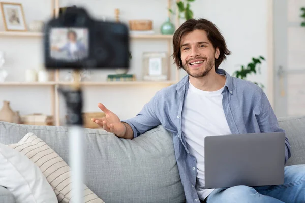 Man blogger looking at camera, talking on video shooting