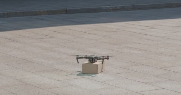 Drone courier volant jusqu'à avec paquet de carton en ville — Video