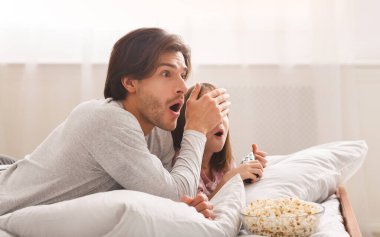 Baba film izlerken kızının gözlerini kapatıyor.