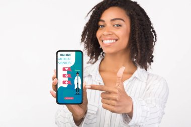 Ekranda çevrimiçi tıbbi hizmetleri olan telefonu tutan kız