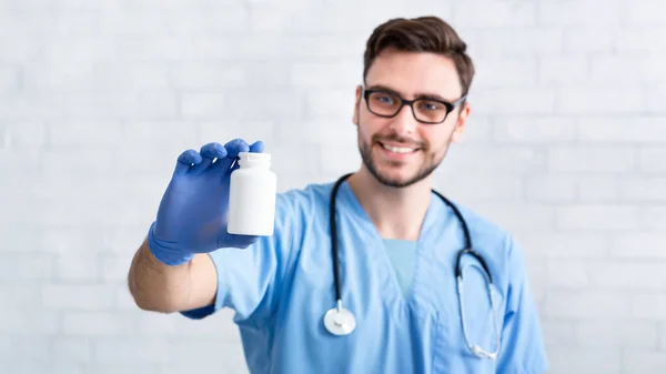 Happy veterinarian doctor in uniform holding bottle of pills at animal clinic, space for design — Stock Photo, Image