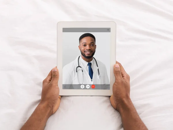 Uomo avendo video chat con il medico di sesso maschile utilizzando tablet — Foto Stock