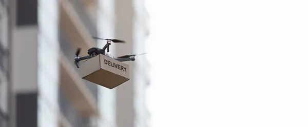 Mały dron dostarczający skrzynkę pocztową przez miasto — Zdjęcie stockowe