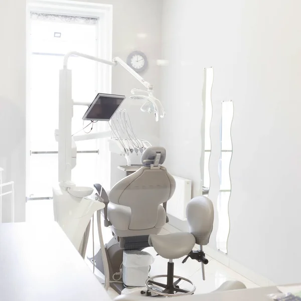 Krzesło dentystyczne i inne akcesoria stosowane przez dentystów w pokoju — Zdjęcie stockowe