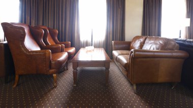 Deri mobilyalarla iş toplantıları için otel odası.