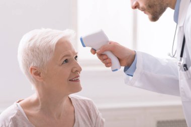 Ateşler klinikteki hastalar için alnı kızılötesi ile ölçer.