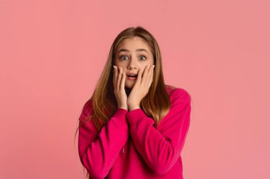 Korkmuş kız elleriyle yüzünü kapatıyor.