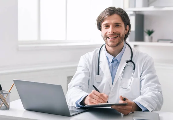 Självsäker läkare fyller sjukdomshistoria på arbetsplatsen på kontoret — Stockfoto