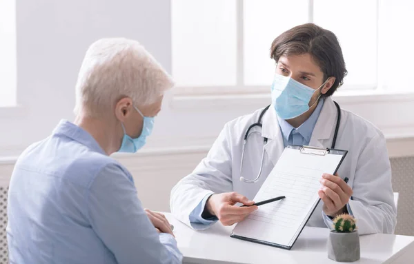 Doctor showing treatment plan to senior woman in hospital