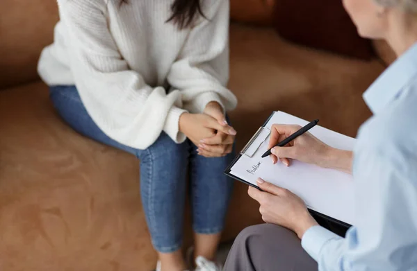 Psicologo irriconoscibile che parla con il cliente che prende appunti seduto in ufficio — Foto Stock