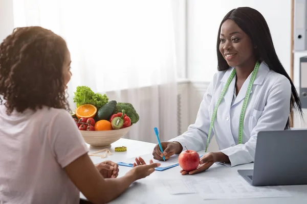 Dietista dando consejos de dieta saludable mujer joven, la celebración de manzana —  Fotos de Stock