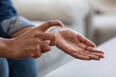 Tanımlanamayan Siyah Kadın Evde Antibakteriyel dezenfektan püskürtüyor